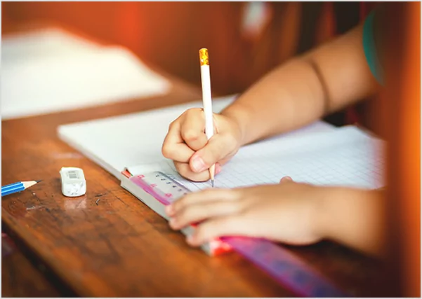 Close-up of a child's hand carefully writing