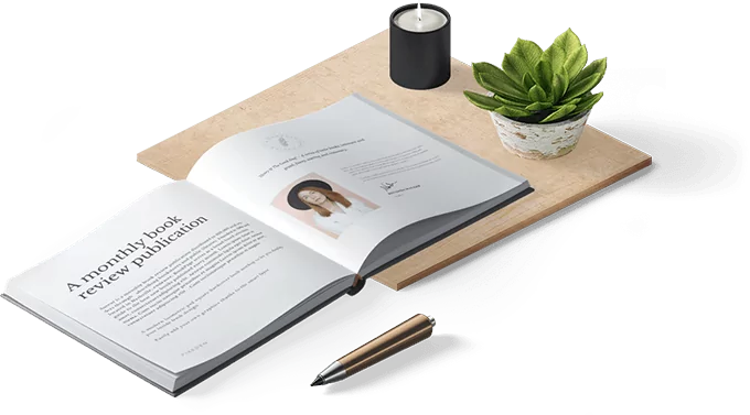 Monthly book review publication open on a desk with a plant and pen, showcasing professional book publishing services.