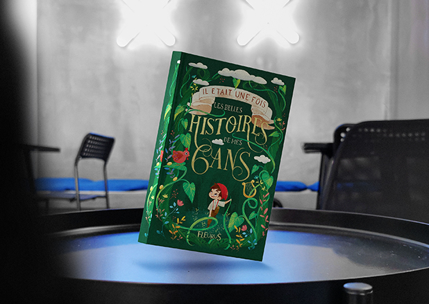 A green French storybook titled "Les Belles Histoires de mes 6 ans" floating above a table.