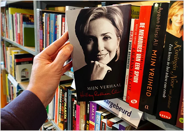 A hand pulling a copy of Hillary Rodham Clinton’s memoir "Mijn Verhaal"