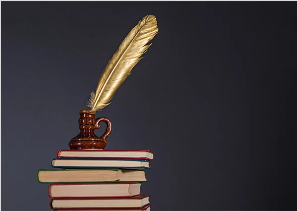 A golden quill pen in an inkwell atop a stack of books, representing prestige publishing and literary excellence.