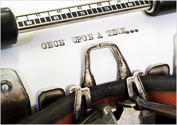 Close-up of a vintage typewriter carriage with the phrase "ONCE UPON A TIME..." freshly typed on white paper, symbolizing professional fiction writing and classic storytelling services.